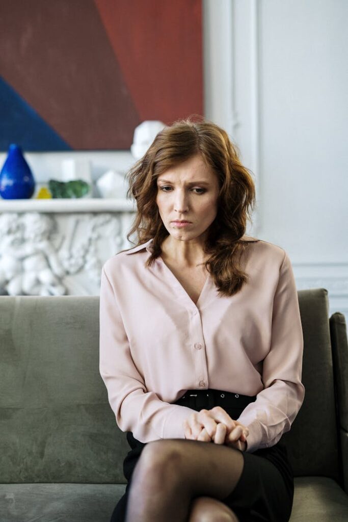 Woman in Pink Blazer Sitting on Gray Sofa